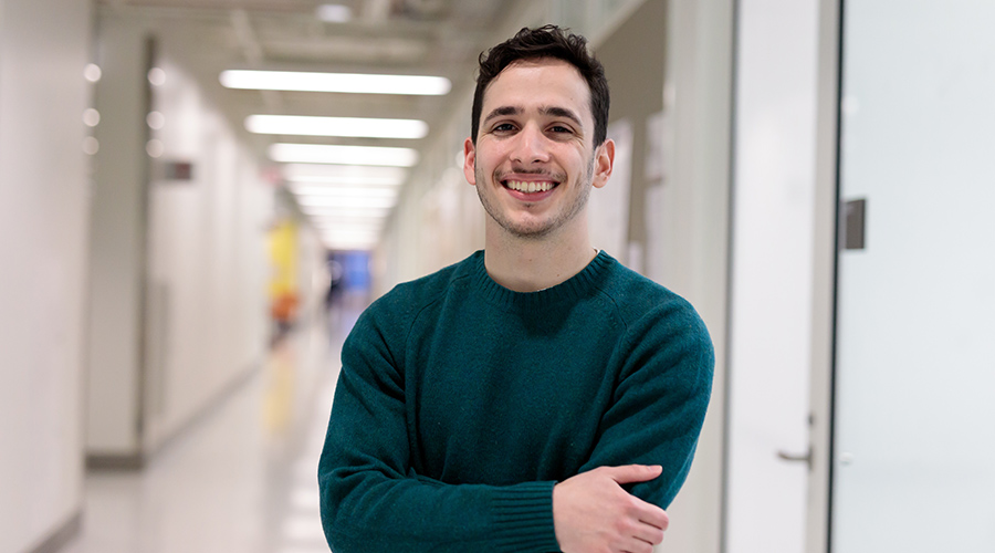 Headshot of Carlos in the lab hallway