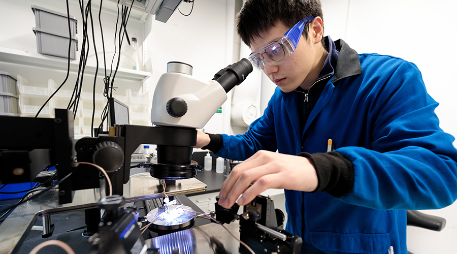 Yahao Dai looking into a microscope