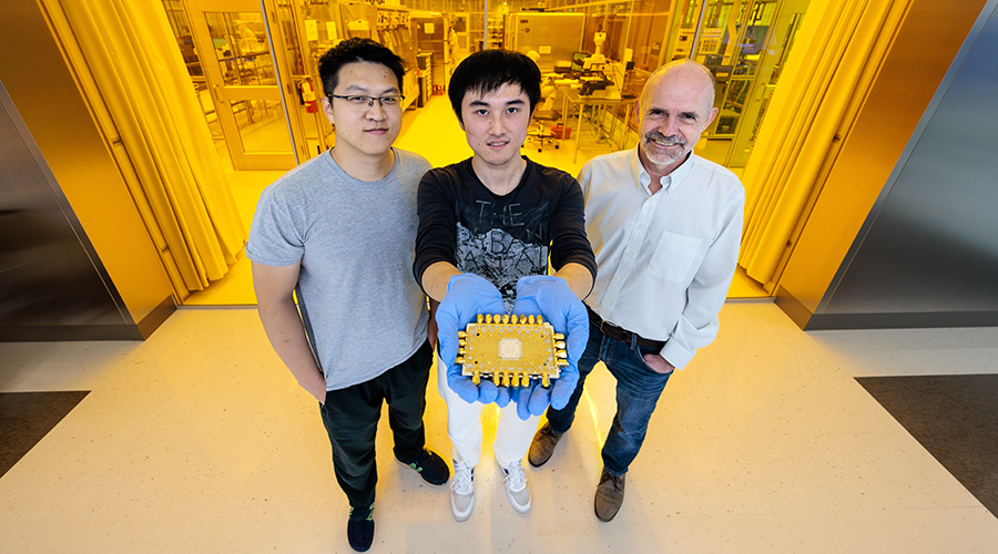UChicago Engineering students and professor showing off modular quantum chip