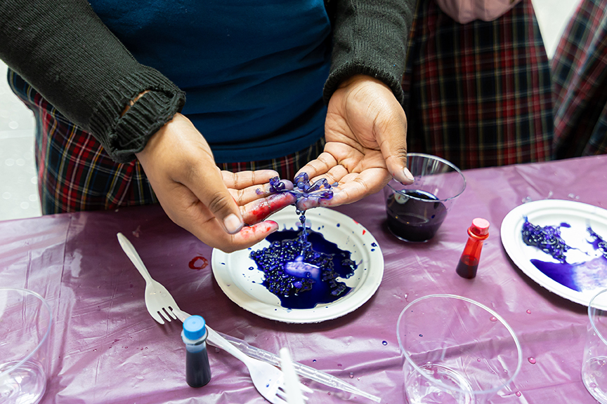 Student’s hands playing with slimy purple chemicals at UChicago Pritzker Molecular Engineering’s 2025 No Small Matter Molecular Engineering Fair