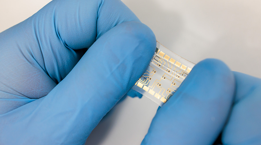 Gloved hands stretch a flexible device