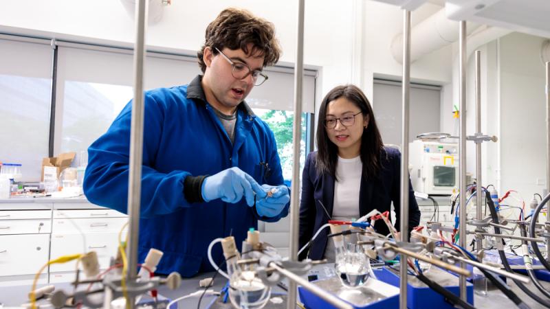 Two scientists in the lab handle materials
