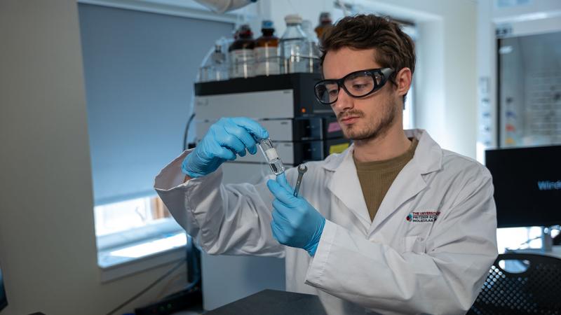 Student handles a vial in lab