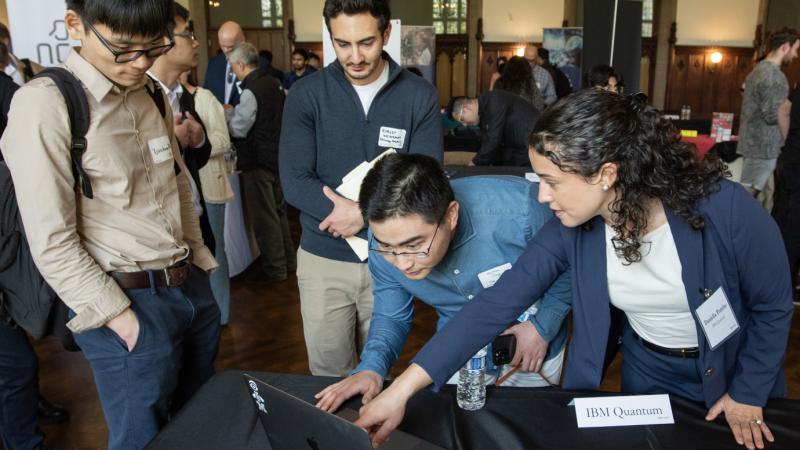 People gather around a laptop