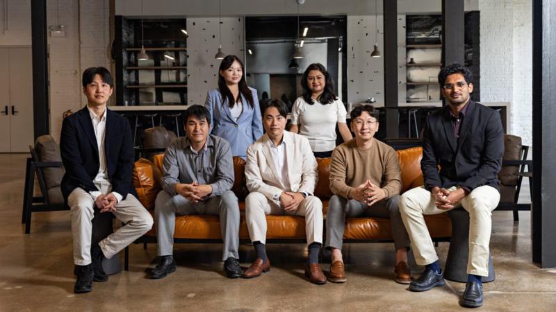 Seven people sitting on and around a couch