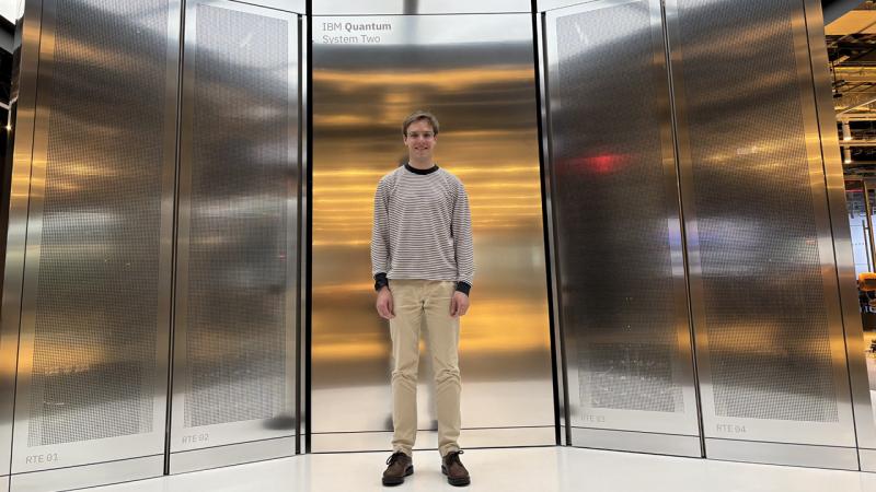 University of Chicago Pritzker School of Molecular PhD student stands in front of the IBM Quantum System Two computer