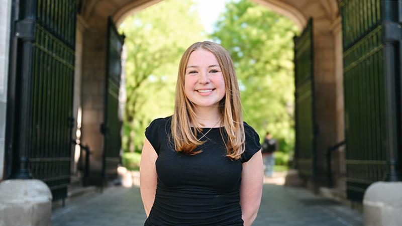 Woman standing in front of campus arch