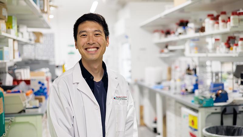 Smiling student in white lab coat