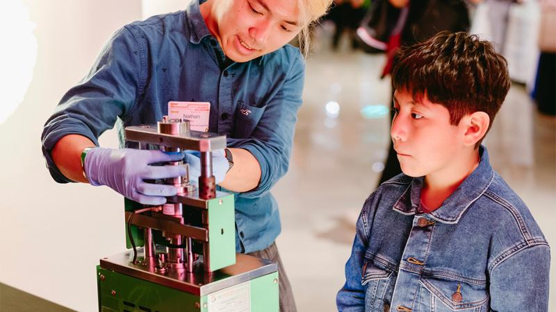 Fourth-year Molecular Engineering major Nathan Hu demonstrates the final step of building a battery. (Griffin Museum of Science and Industry / Jason Smith)