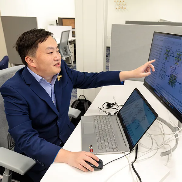Postdoc sits at two computers