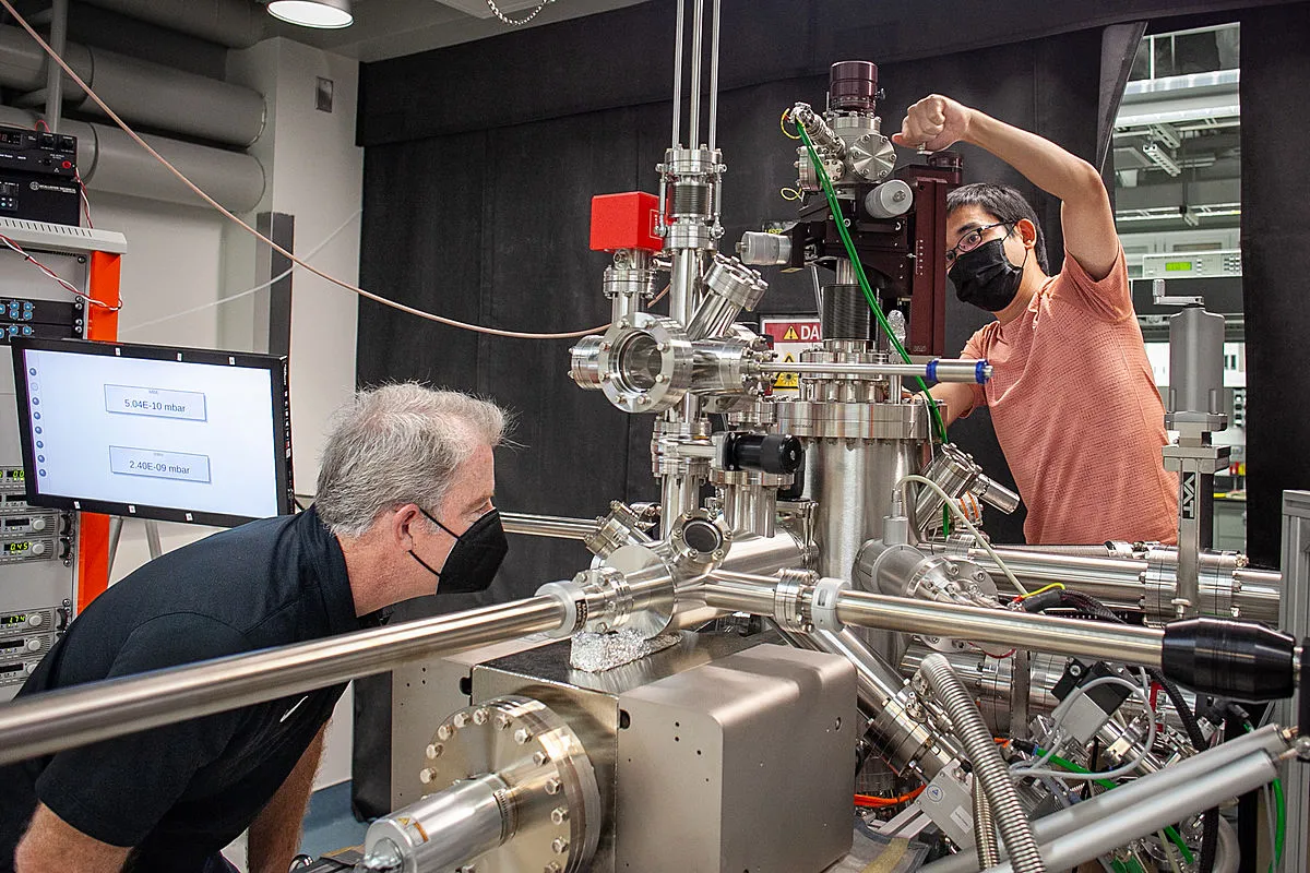 Michael Rodgers and Chenhui Yan work together on lab equipment
