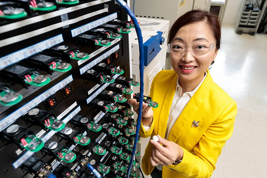 Shirley Meng with a bank of batteries