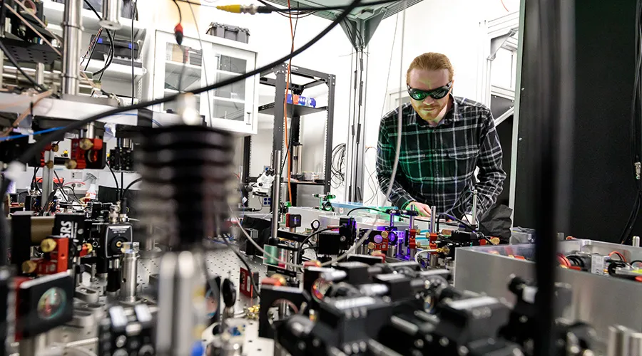 Noah Glachman studies an optical table in Bernien Lab