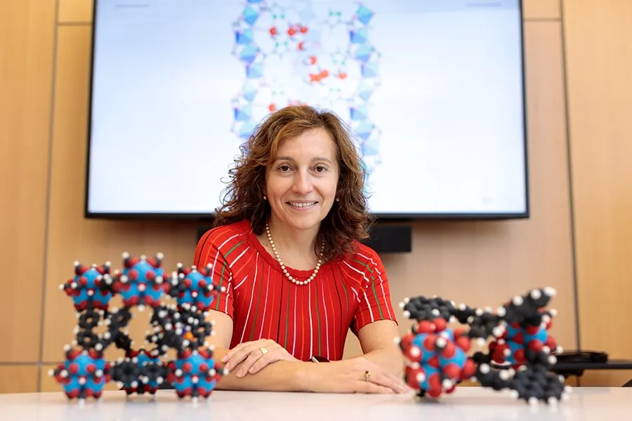 UChicago Prof. Laura Gagliardi sitting at a desk behind two models of molecules