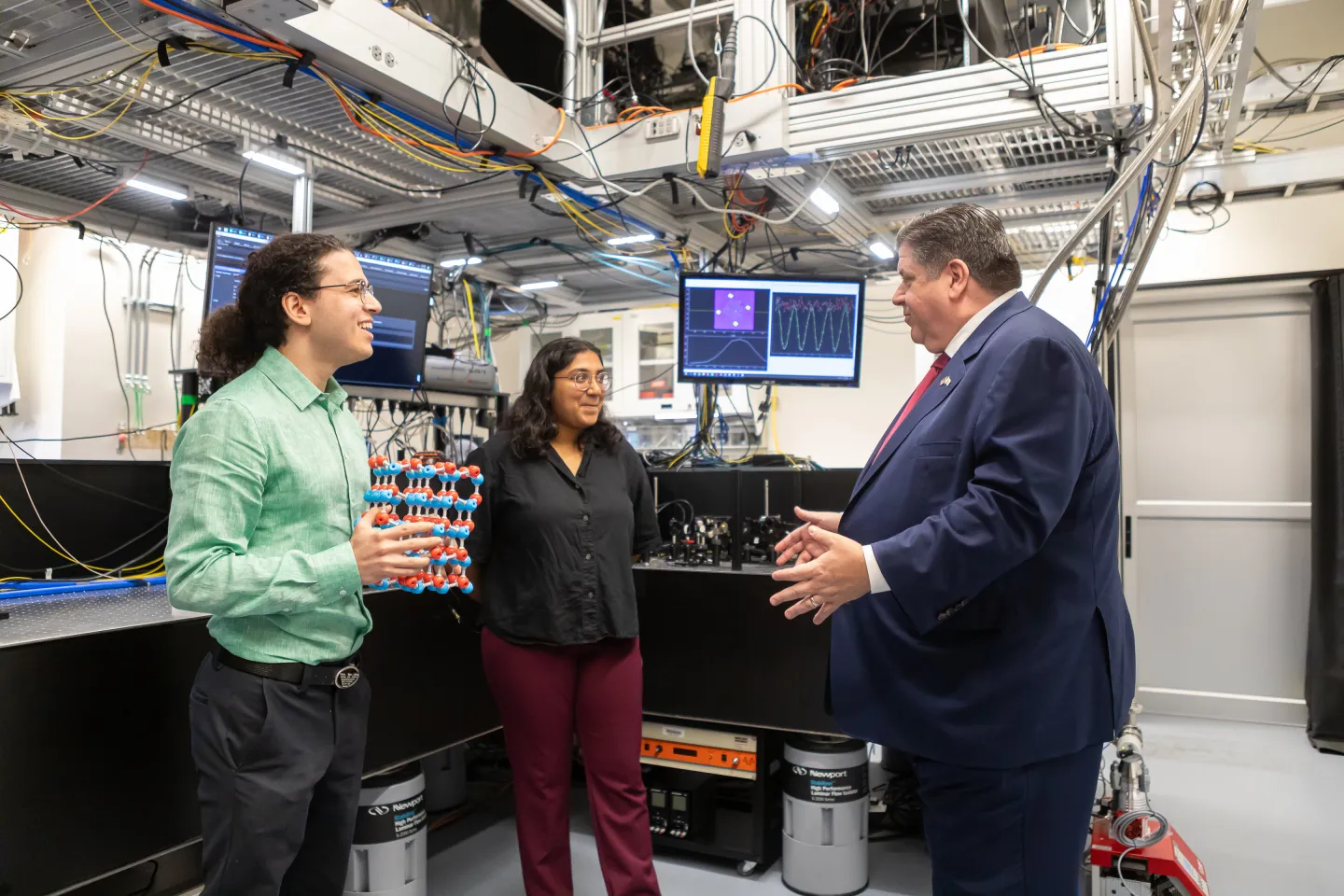 Graduate students presenting research inside a nanofabrication laboratory during a visit from Governor J.B. Pritzker.