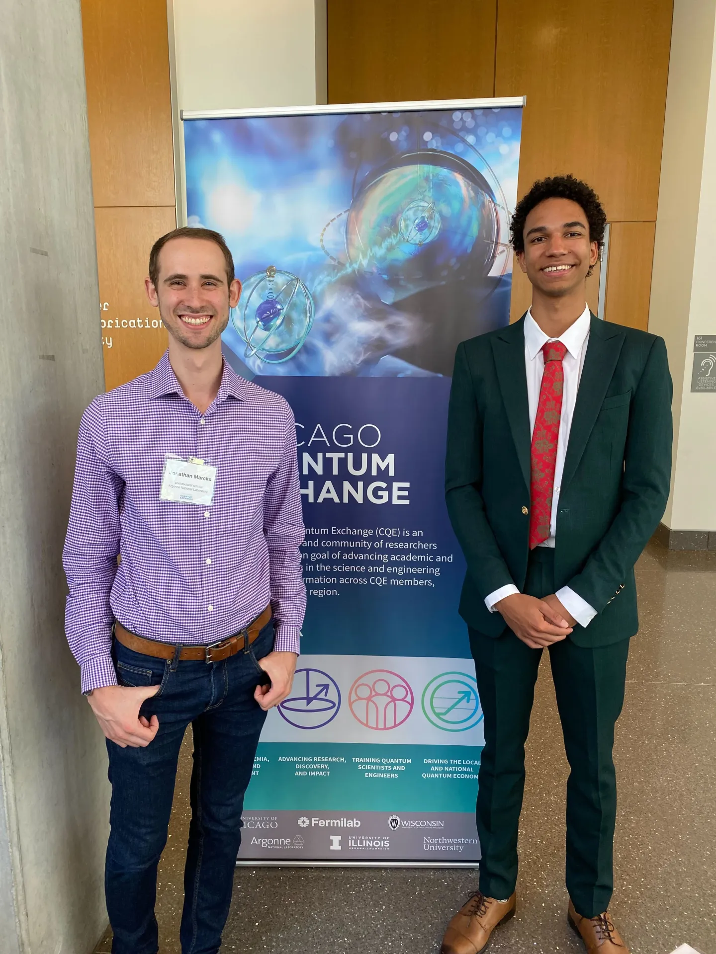 Two researchers standing beside a Chicago Quantum Exchange banner at a scientific event.