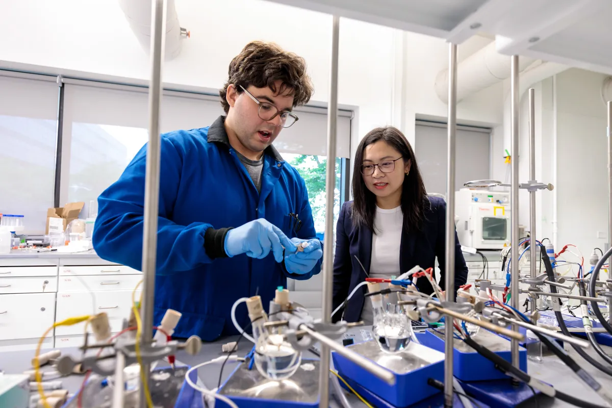 Two scientists in the lab handle materials