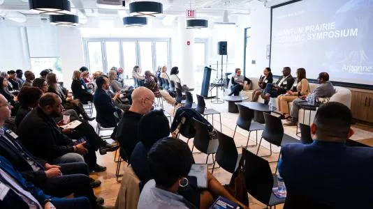 Rows of people sitting in seats, watching a panel discussion