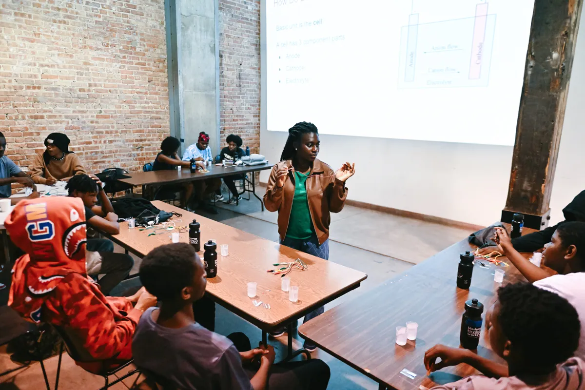 Scientist stands in front of a group of high school students