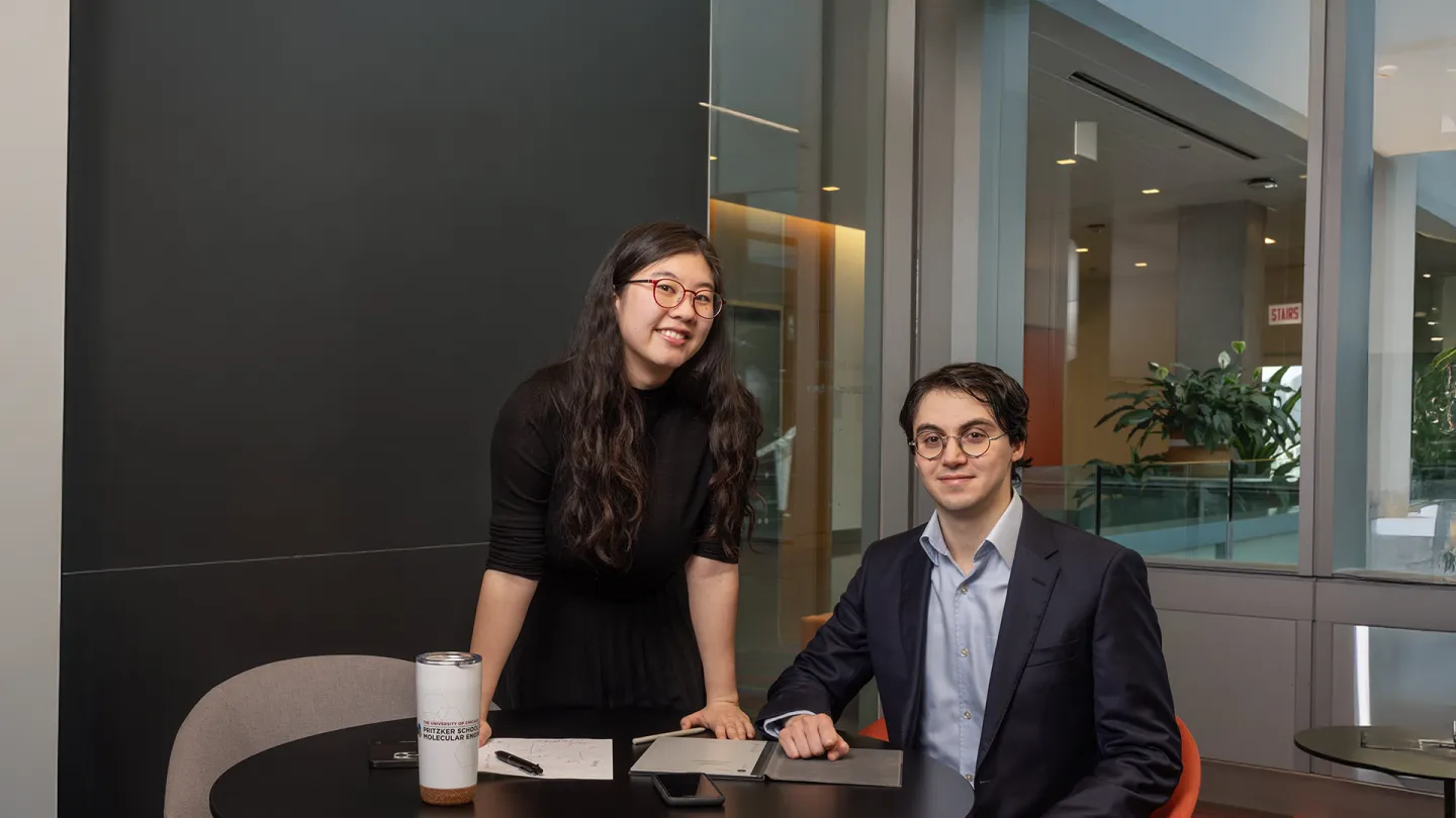 Students sitting and standing at a desk
