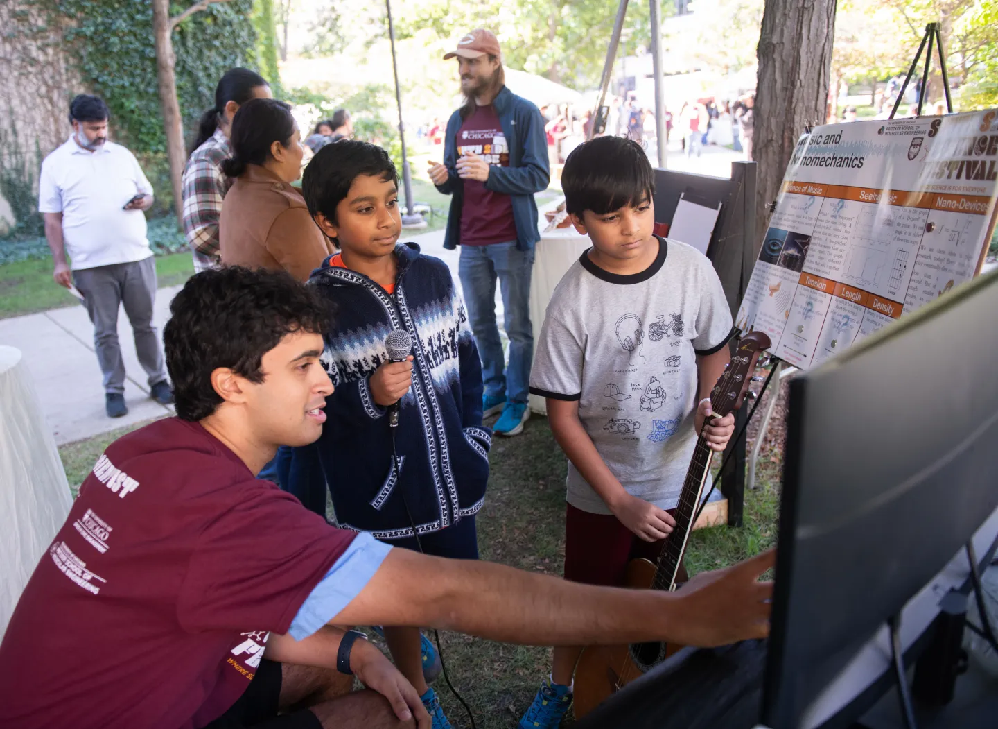 Children learn science lessons from a University of Chicago student at outdoor festival
