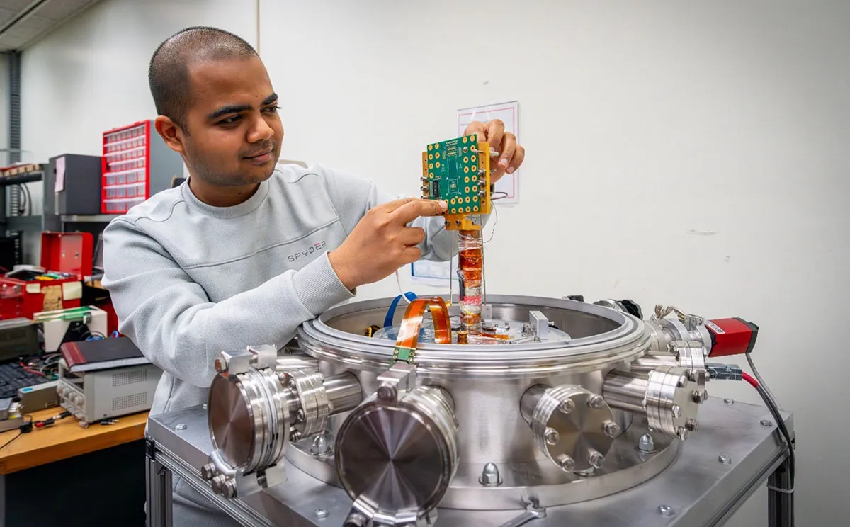 Scientist working on  custom circuit board designed to measure chip performance in cryogenic environments
